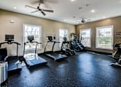 Thumbnail 15 of 41 - A spacious gym with a variety of equipment including treadmills, elliptical machines, and a weight bench.