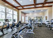 Thumbnail 6 of 41 - A gym with a variety of equipment including treadmills, weights, and exercise machines.