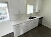 Thumbnail 22 of 25 - A kitchen with white cabinets and a sink.