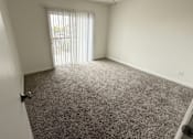 Thumbnail 24 of 25 - A room with a ceiling fan and carpeted floor.