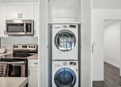 Thumbnail 9 of 18 - A modern kitchen with a washer and dryer built into the cabinetry.