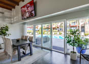 Thumbnail 18 of 28 - a dining area with a table and chairs and a sliding glass door leading to a pool