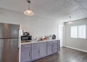 Thumbnail 23 of 28 - a kitchen with gray cabinets and a stainless steel refrigerator