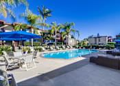 Thumbnail 22 of 28 - a swimming pool with lounge chairs and umbrellas