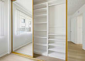 Thumbnail 8 of 24 - A white closet with a mirror and shelves.