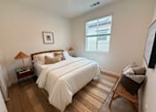 Thumbnail 9 of 27 - A bedroom with two beds and a chair.