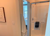 Thumbnail 11 of 27 - A bathroom with a glass shower door and a towel hanging on the door.