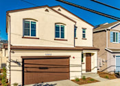Thumbnail 17 of 27 - A two-story house with a brown garage door.
