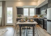 Thumbnail 10 of 27 - an open kitchen and dining room with a table and chairs at Citron Apartment Homes, Riverside, 92506