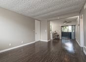 Thumbnail 29 of 34 - A room with wooden floors and a ceiling fan.