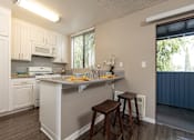 Thumbnail 11 of 34 - A kitchen with white cabinets and a grey island.