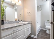 Thumbnail 32 of 34 - A bathroom with a sink, mirror, and toilet.