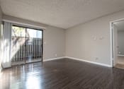 Thumbnail 34 of 34 - A room with wooden floors and a sliding glass door.