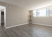 Thumbnail 27 of 34 - A room with a wooden floor and a window with blinds.