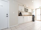 Thumbnail 14 of 34 - A kitchen with white cabinets and a white door.