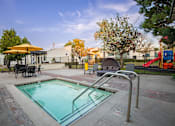 Thumbnail 3 of 34 - A small pool with a metal ladder and a table with chairs around it.