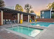 Thumbnail 10 of 34 - A small pool with a diving board is surrounded by a brick wall.