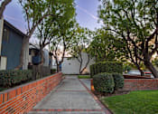 Thumbnail 25 of 34 - A residential street with a sidewalk and trees.