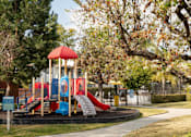 Thumbnail 17 of 34 - A playground with a red and blue slide and a red and yellow tower.