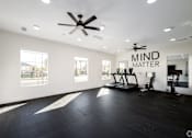 Thumbnail 6 of 33 - A spacious room with a ceiling fan and exercise equipment.