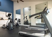 Thumbnail 7 of 34 - A gym with treadmills, elliptical machines, and other exercise equipment.