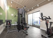 Thumbnail 5 of 34 - A gym with a treadmill, elliptical trainer and a stationary bike.