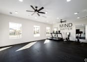 Thumbnail 6 of 33 - A spacious room with a ceiling fan and exercise equipment.