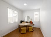Thumbnail 12 of 33 - A white room with a table and chairs.
