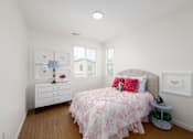 Thumbnail 27 of 33 - A bedroom with a bed, nightstand, and dresser.