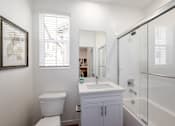 Thumbnail 26 of 33 - A white toilet sits next to a sink in a bathroom.