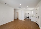 Thumbnail 23 of 33 - A kitchen with white cabinets and a wooden floor.
