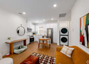 Thumbnail 2 of 33 - A modern kitchen with a yellow couch and a painting on the wall.