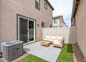Thumbnail 8 of 33 - A patio with a couch, chairs, and an air conditioning unit.