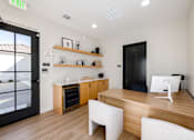Thumbnail 17 of 33 - A modern office with a wooden desk and white chairs.