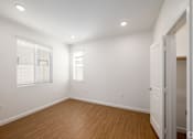 Thumbnail 20 of 33 - A room with wooden floors and white walls.