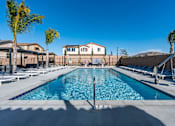 Thumbnail 1 of 33 - A large swimming pool surrounded by palm trees and lounge chairs.