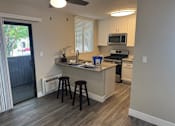 Thumbnail 9 of 34 - A kitchen with a white counter and black stools.