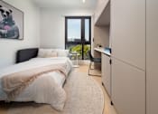 Thumbnail 26 of 29 - A bedroom with a large bed and a window overlooking the city.