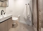 Thumbnail 25 of 29 - A bathroom with a toilet, sink, and towel rack.