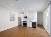Thumbnail 9 of 33 - A modern kitchen with white cabinets and stainless steel appliances.