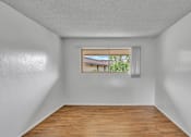 Thumbnail 10 of 13 - A room with a window showing a view of a house and greenery outside.