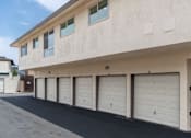 Thumbnail 8 of 13 - A building with a row of garage doors and a sign on the gate.