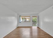 Thumbnail 3 of 13 - A room with white walls and a wooden floor.