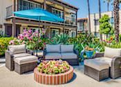 Thumbnail 8 of 25 - A patio with a blue umbrella and furniture.