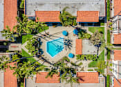 Thumbnail 10 of 25 - A swimming pool surrounded by trees and buildings.