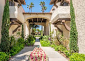 Thumbnail 12 of 25 - A garden pathway leads to a building with arches.