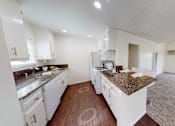 Thumbnail 7 of 25 - A kitchen with white cabinets and a granite countertop.