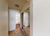 Thumbnail 14 of 25 - A hallway with white walls and a brown carpet.