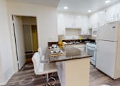 Thumbnail 18 of 25 - A kitchen with white cabinets and a white refrigerator.