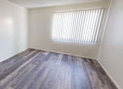 Thumbnail 24 of 25 - A room with a window and wooden flooring.